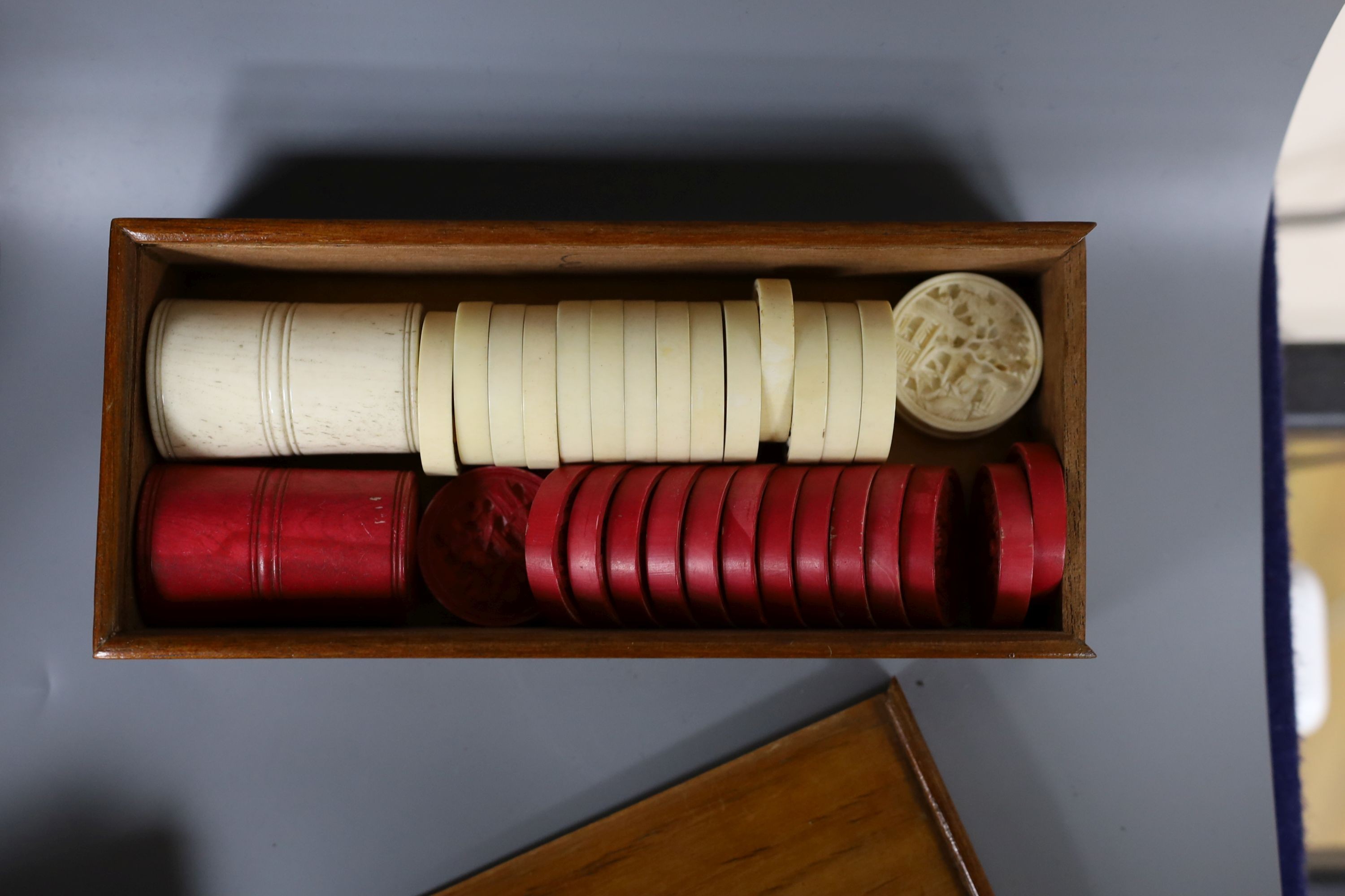 A 19th century bone and ivory draughts set, engraved mother of pearl gaming counters and stained bone tokens, all boxed